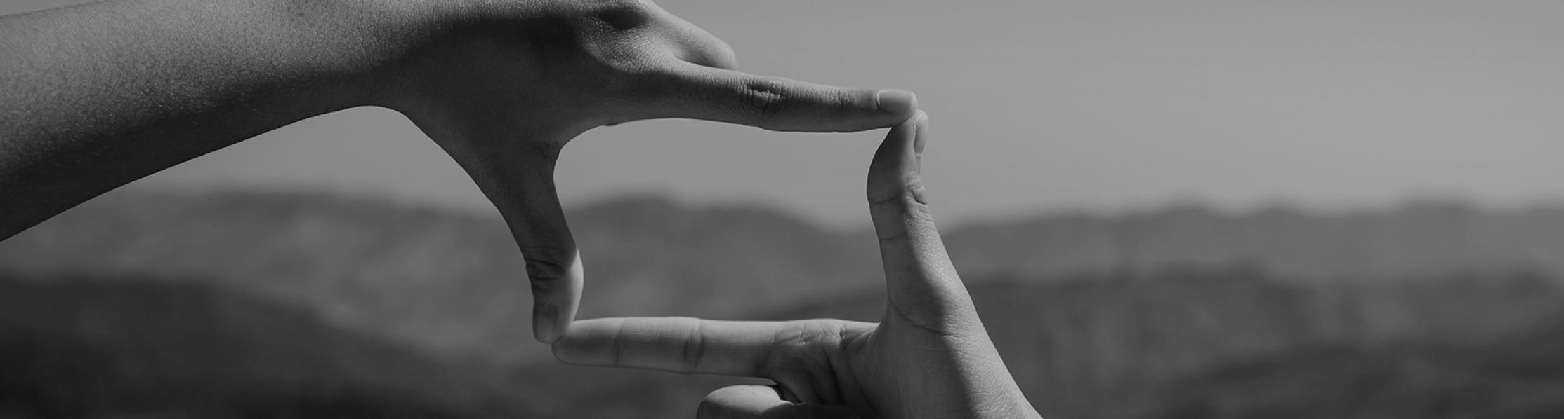 Graphic showing two index fingers and two thumbs joining to make a camera shape 