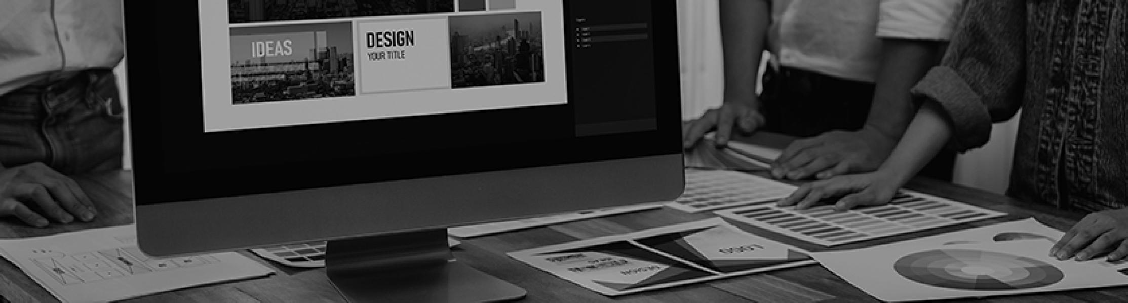 Graphic showing people standing around a desk with a screen and papers with designs