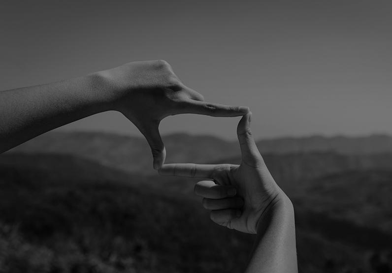 Graphic showing two index fingers and two thumbs joining to make a camera shape 